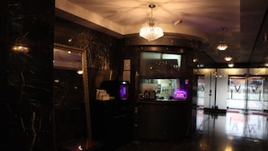 A modern lobby with marble walls, a reception desk, and a chandelier. - V Hotel (Busan)