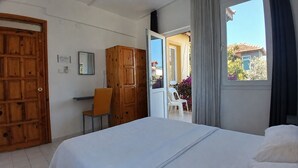 A bedroom with a bed, wooden wardrobe, and a desk with a chair. - Sarihan Apart Otel (Fethiye)