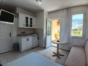 Eine kleine Küche mit Essbereich, einer Couch und einem Fenster mit Blick.
