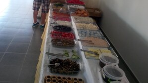 A buffet setup with various food items and a person serving. - Hotel Nazar Garden (Fethiye)