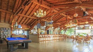 A spacious indoor area with a pool table, wooden ceiling beams, and a reception desk. - Milkyway Apart & Hotels (Fethiye)
