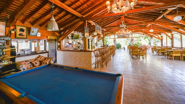 A pool table in a wooden-floored room with a reception area and bar. - Milkyway Apart & Hotels (Fethiye)
