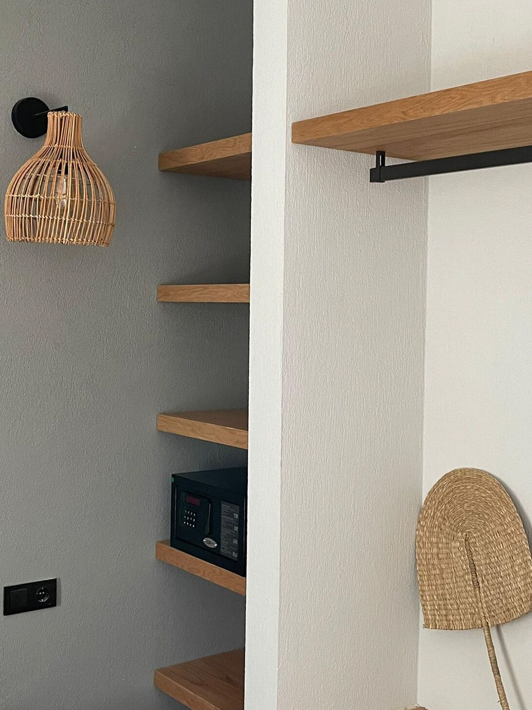 Een modern interieur met houten planken, een geweven hanglamp en een wanddecoratie.