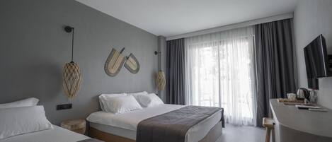 A modern hotel room with two beds, a desk, and a large window with curtains.