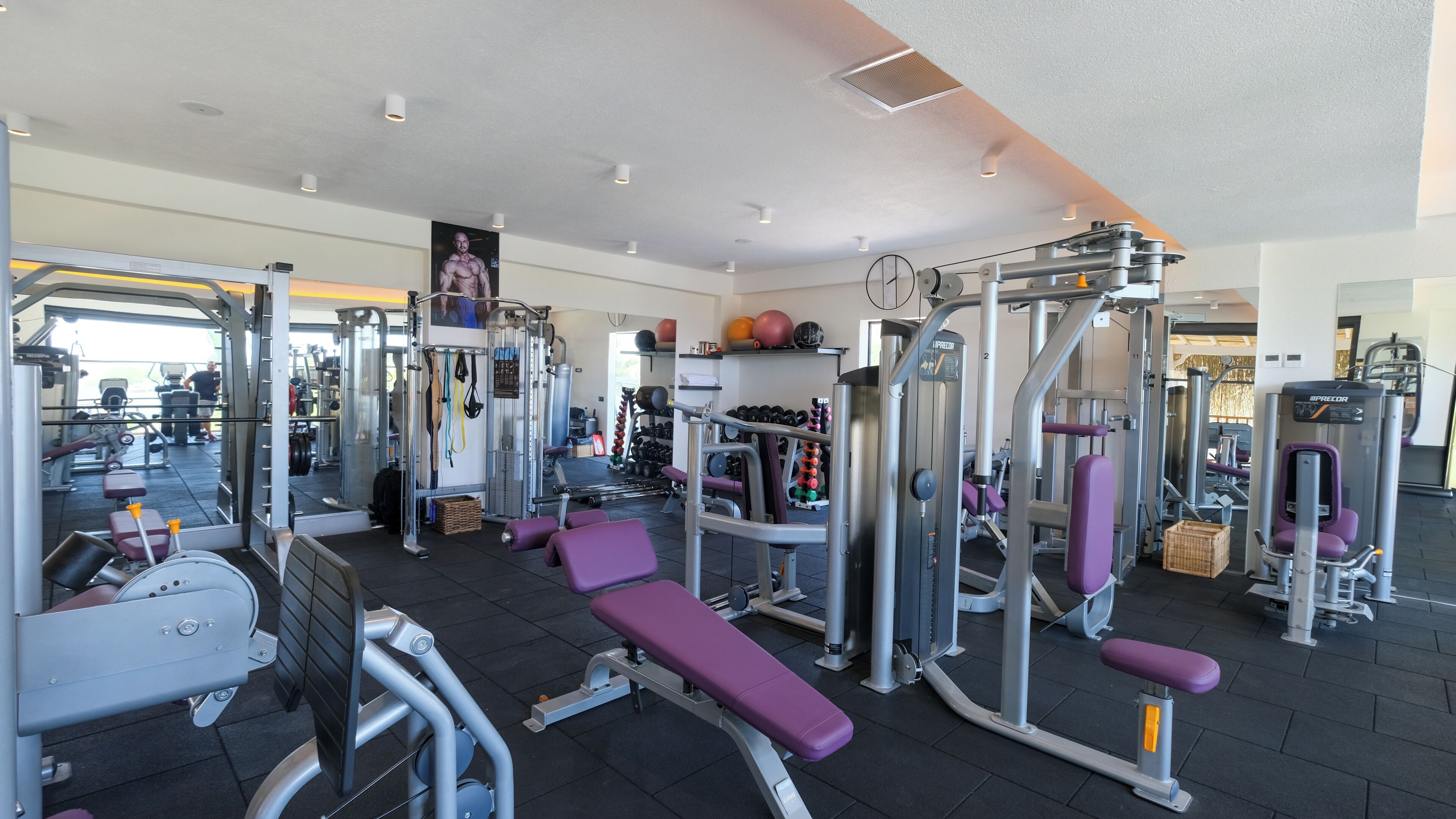 Une salle de sport équipée de divers appareils d’entraînement, notamment des machines à poids et des poids libres.