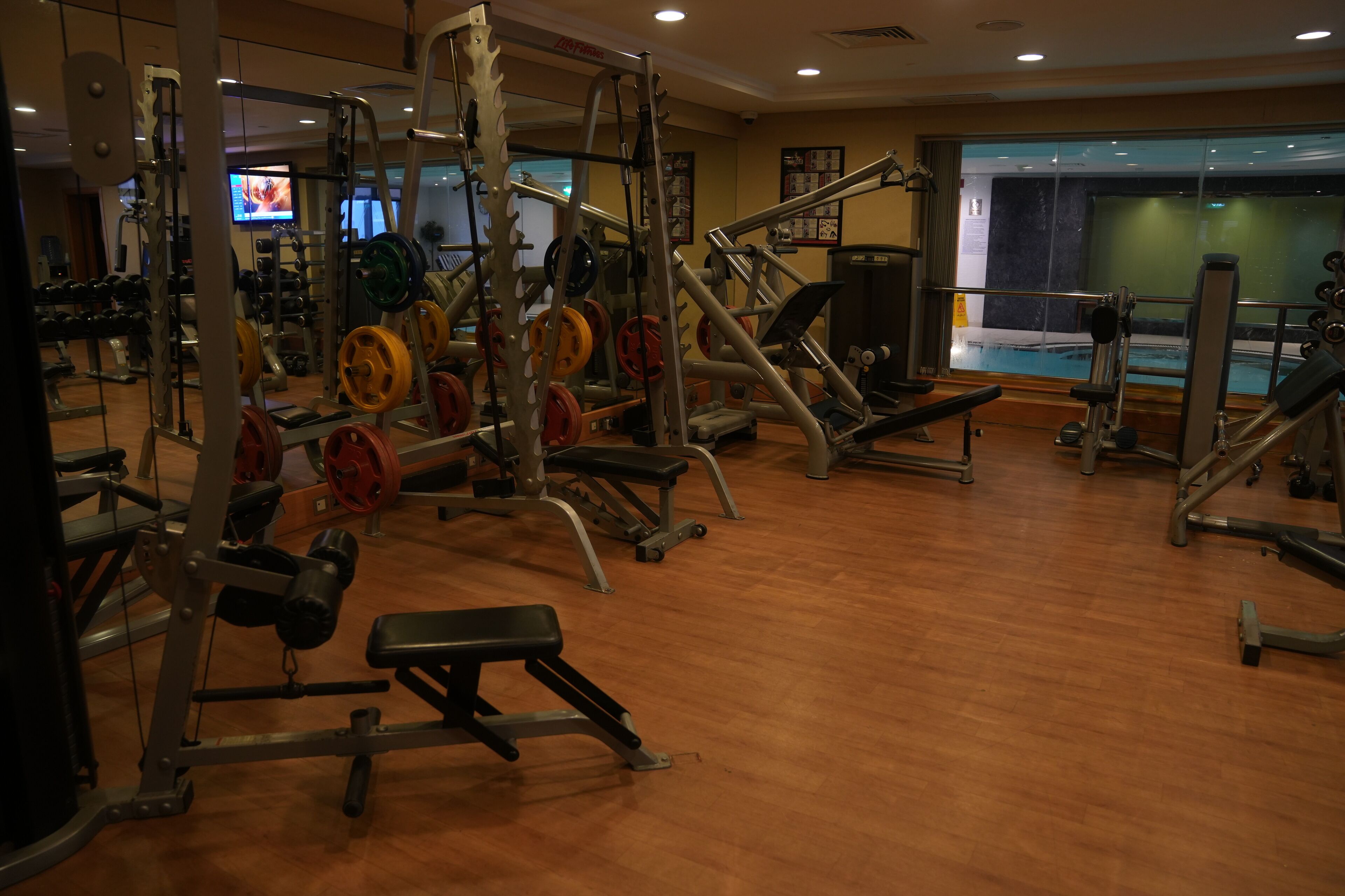 Un gimnasio con equipos de halterofilia variados, incluyendo bancos y pesas.