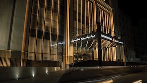 Ein modernes Gebäude mit beleuchteter Schilderung, auf der in verschiedenen Sprachen "Millennium Central" steht.