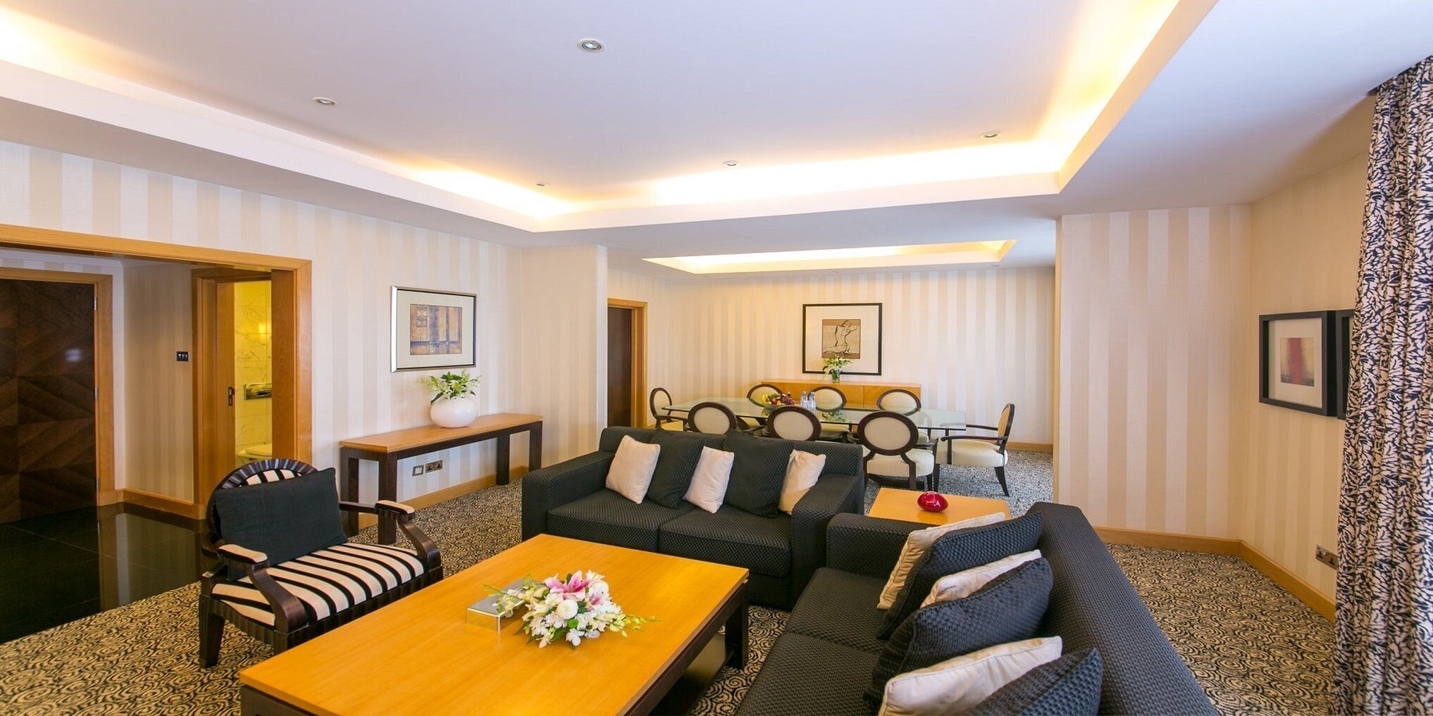 Una sala de estar moderna con un conjunto de sofá, una mesa de centro y un comedor con una mesa y sillas.
