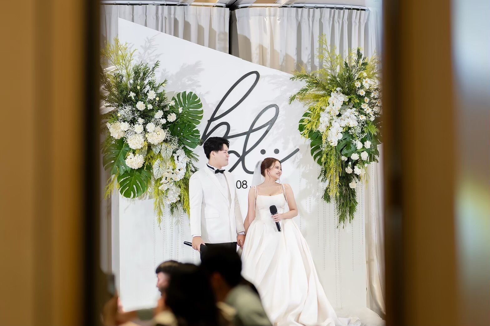 Una ceremonia de boda con un fondo blanco y decoración floral.