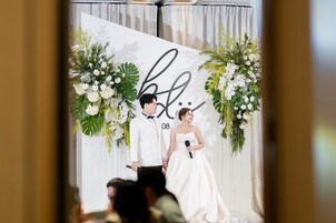 Una ceremonia de boda con un fondo blanco y decoración floral.