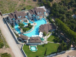 A multi-story hotel with a central swimming pool, multiple balconies, and a well-maintained lawn area. - Mozaik Swim Up Hotel and Apartments (Fethiye)