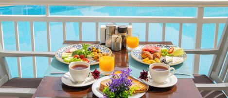 A poolside breakfast setup with a view of a hotel and pool.