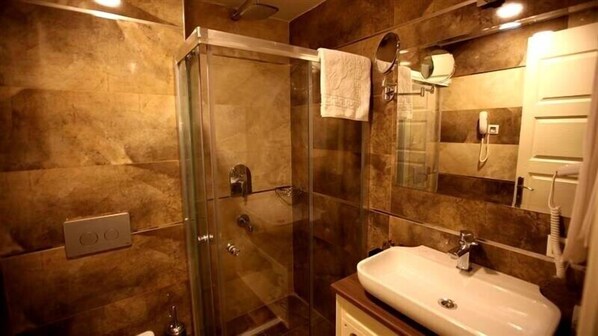 Un baño con cabina de ducha de vidrio, un lavabo y un espejo.