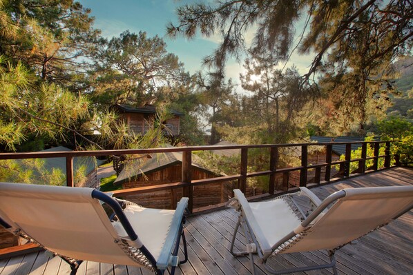 A wooden deck with two hammocks overlooking a forested area. - Chakra Beach Kabak (Fethiye)