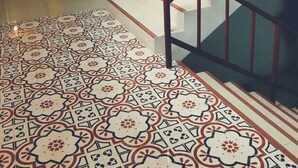 A staircase with a patterned floor leading to a landing. - Machima House (Phuket)