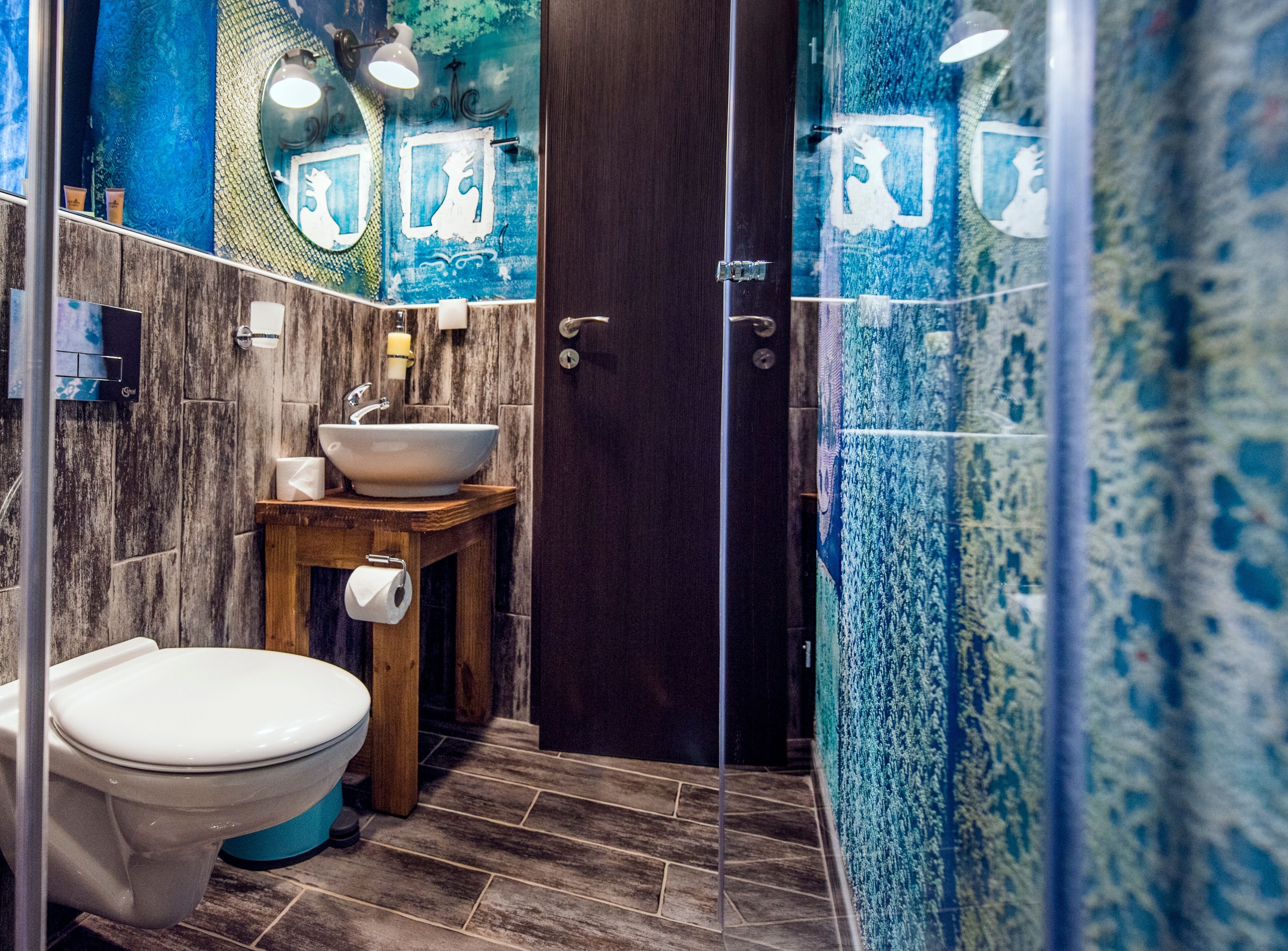 Een badkamer met toilet, wastafel en spiegel.