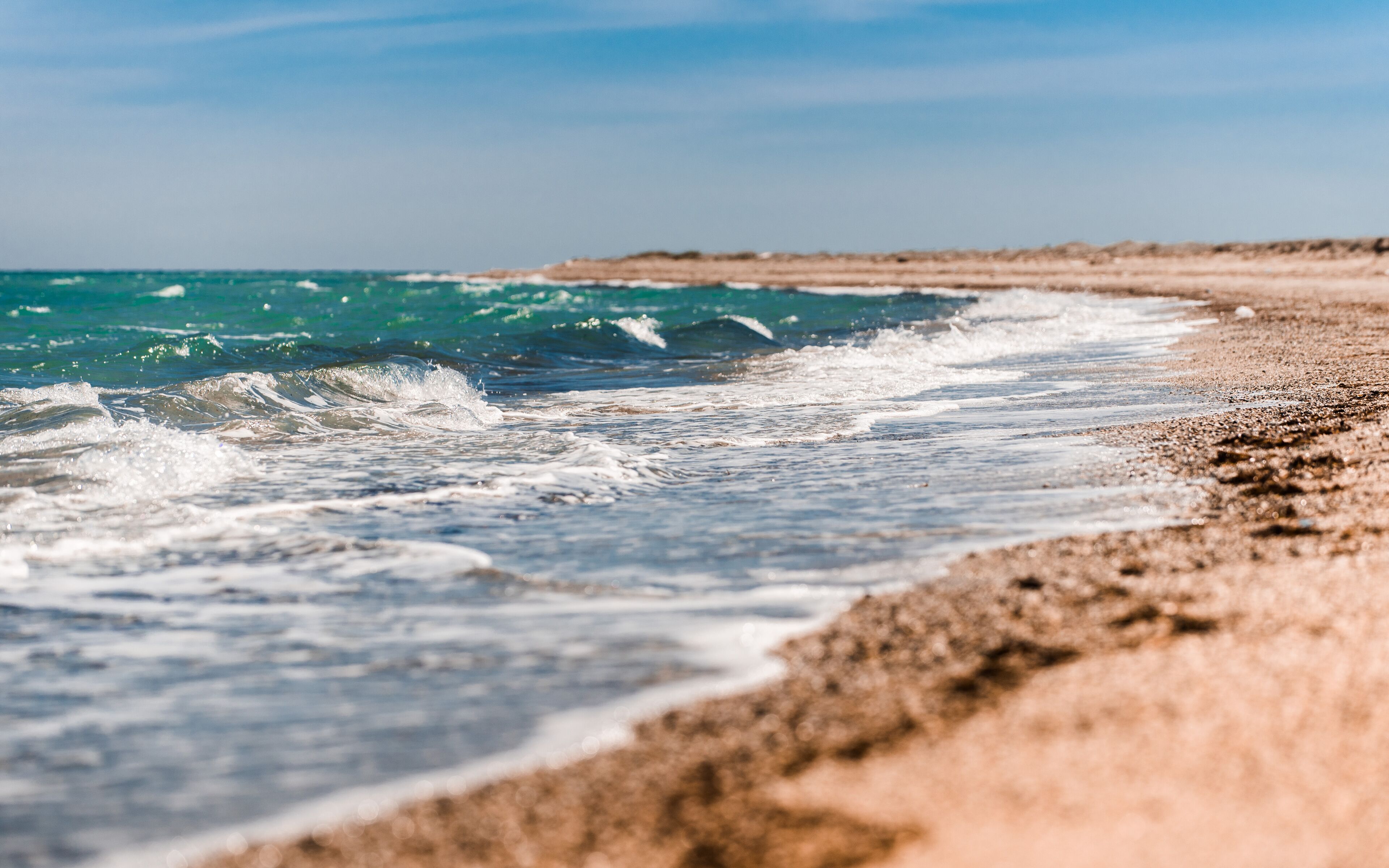 A beach with waves crashing onto the shore.