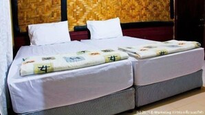 A double bed with white bedding and a patterned blanket, set against a woven wall. - Khaochan Resort (Pak Phayun)