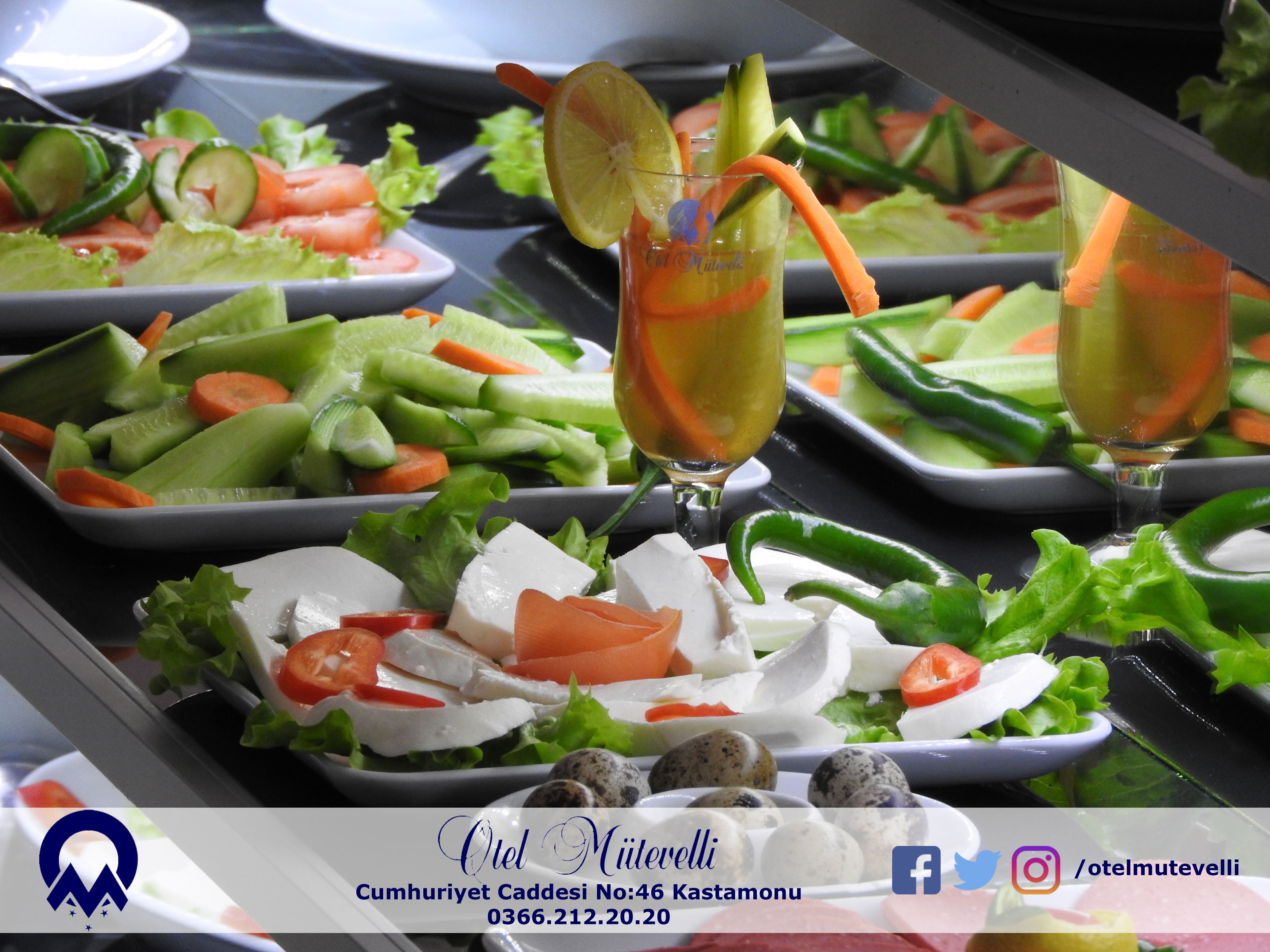 Una mesa de buffet con ensaladas variadas y un vaso de una bebida amarilla.