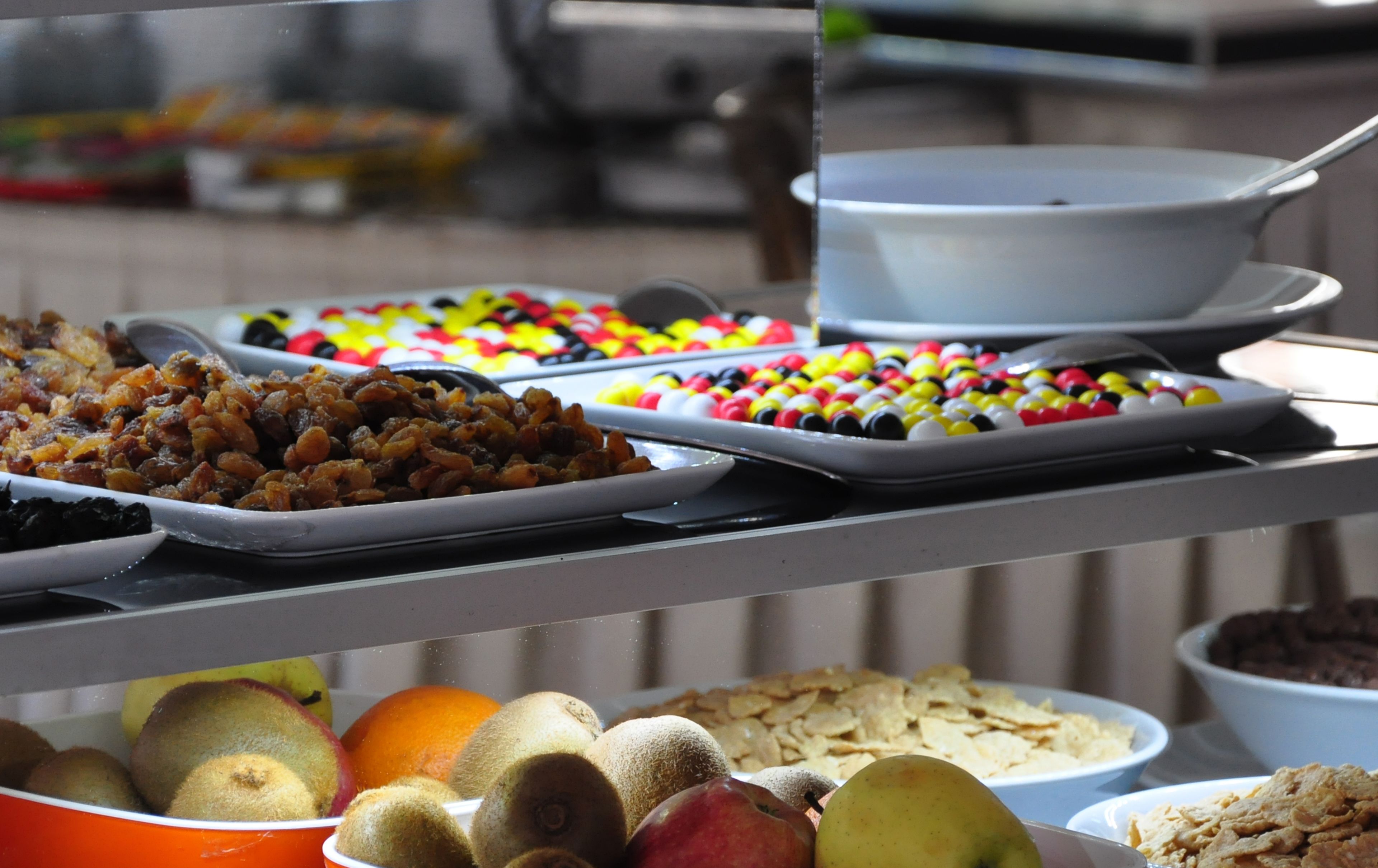 A buffet with various food items including fruits, nuts, and candies.