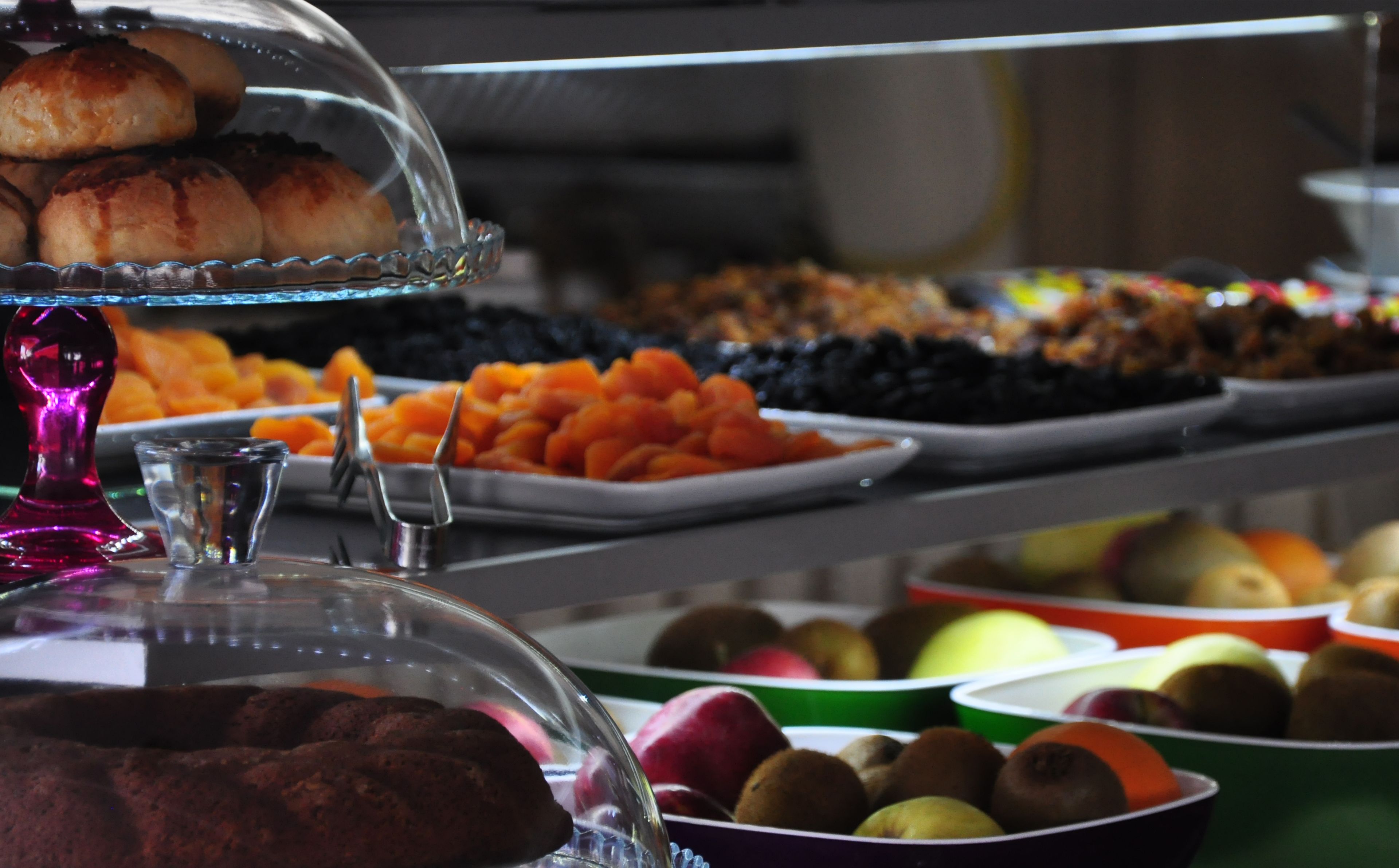 Un buffet proposant une variété de plats, notamment des pâtisseries, des fruits et des légumes.