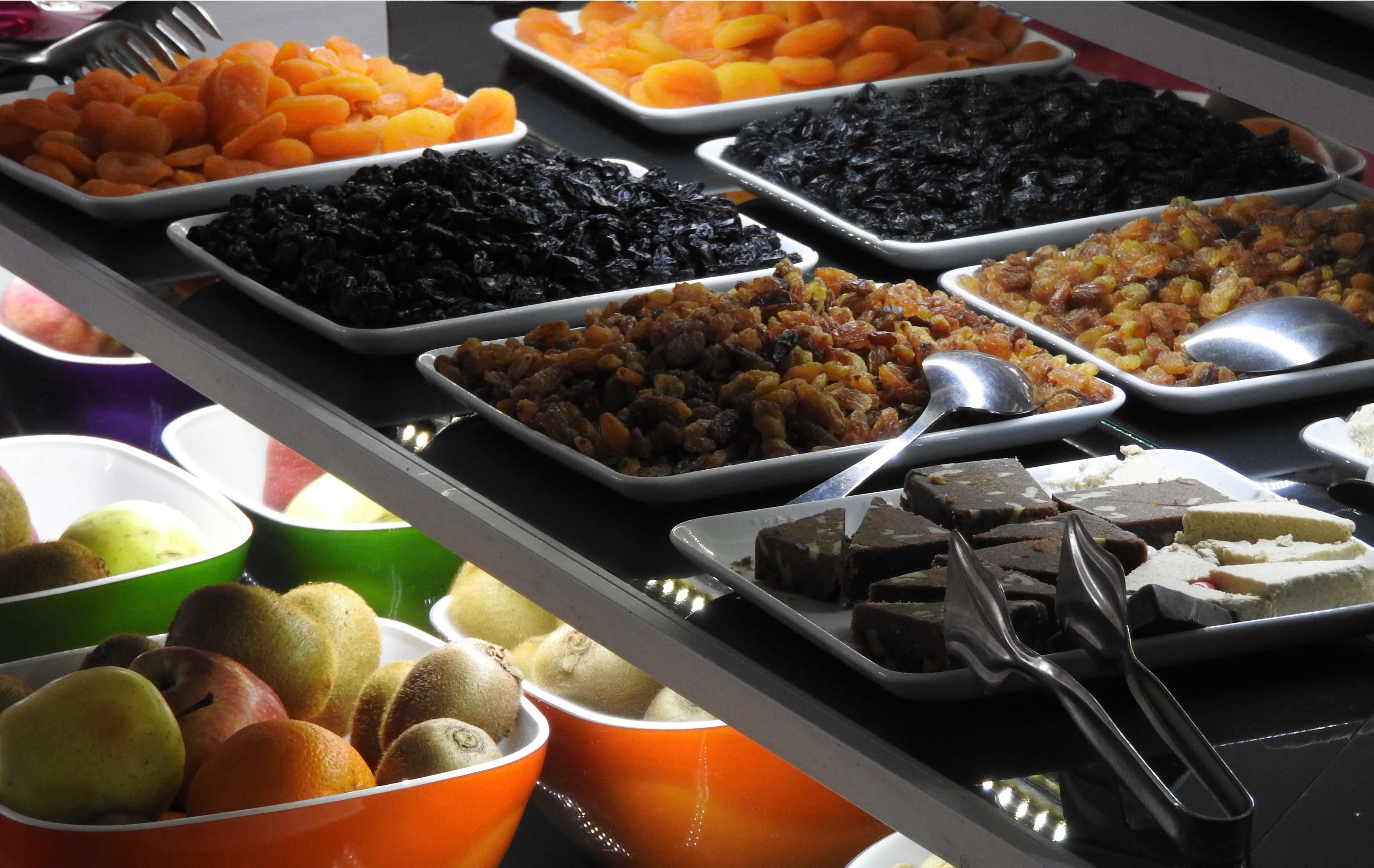 A buffet with various food items including fruits, vegetables, and desserts.