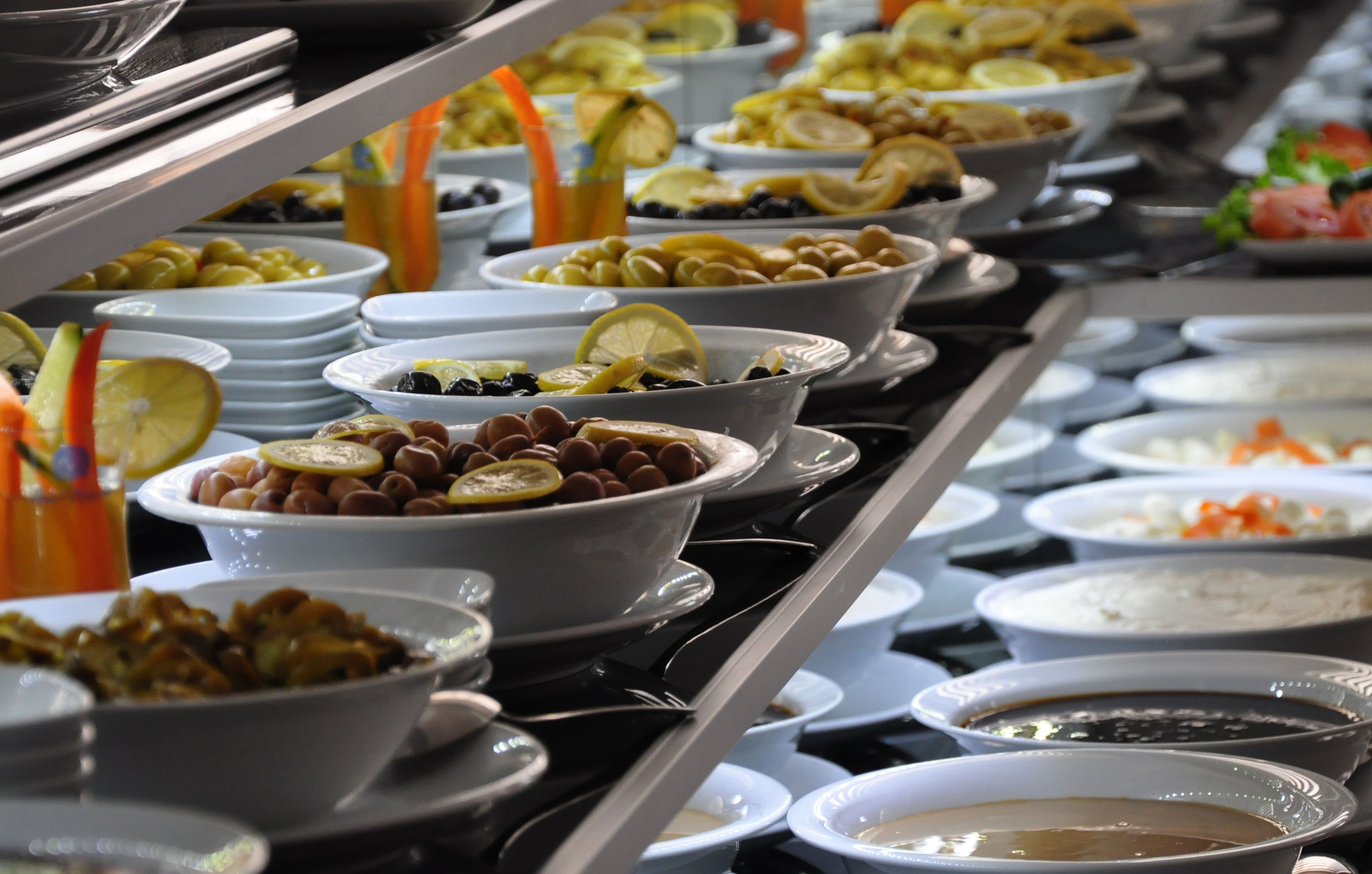 A buffet with various dishes including salads, fruits, and desserts.