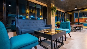 Una sala de estar moderna con un sofá azul, una mesa de centro de vidrio y un sillón azul.