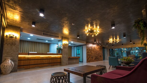 Un vestíbulo moderno con mostrador de recepción, zona de estar e iluminación decorativa.