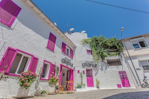 A building with white walls and pink shutters, labeled "alasan alanu". - Alacati Alanur Otel (Cesme)