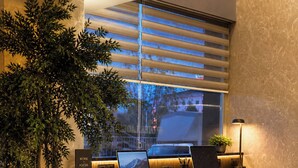A modern workspace with two laptops, a potted plant, and a desk with chairs. - Laodikya Otel (Denizli)