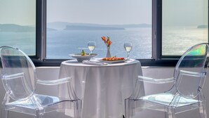 Mesa para dos con vistas al mar a través de amplios ventanales.