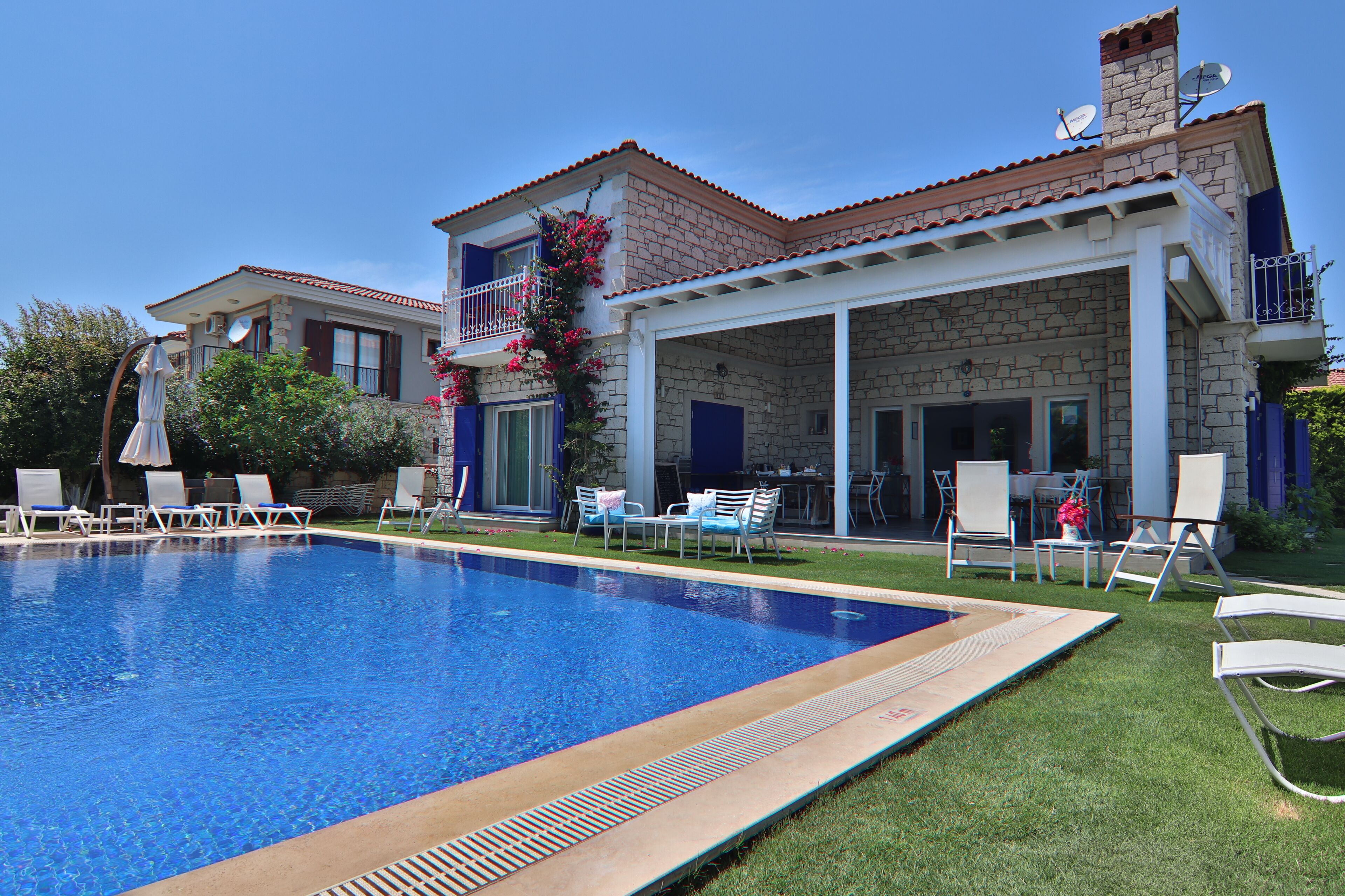 A pool area with lounge chairs and a covered patio.