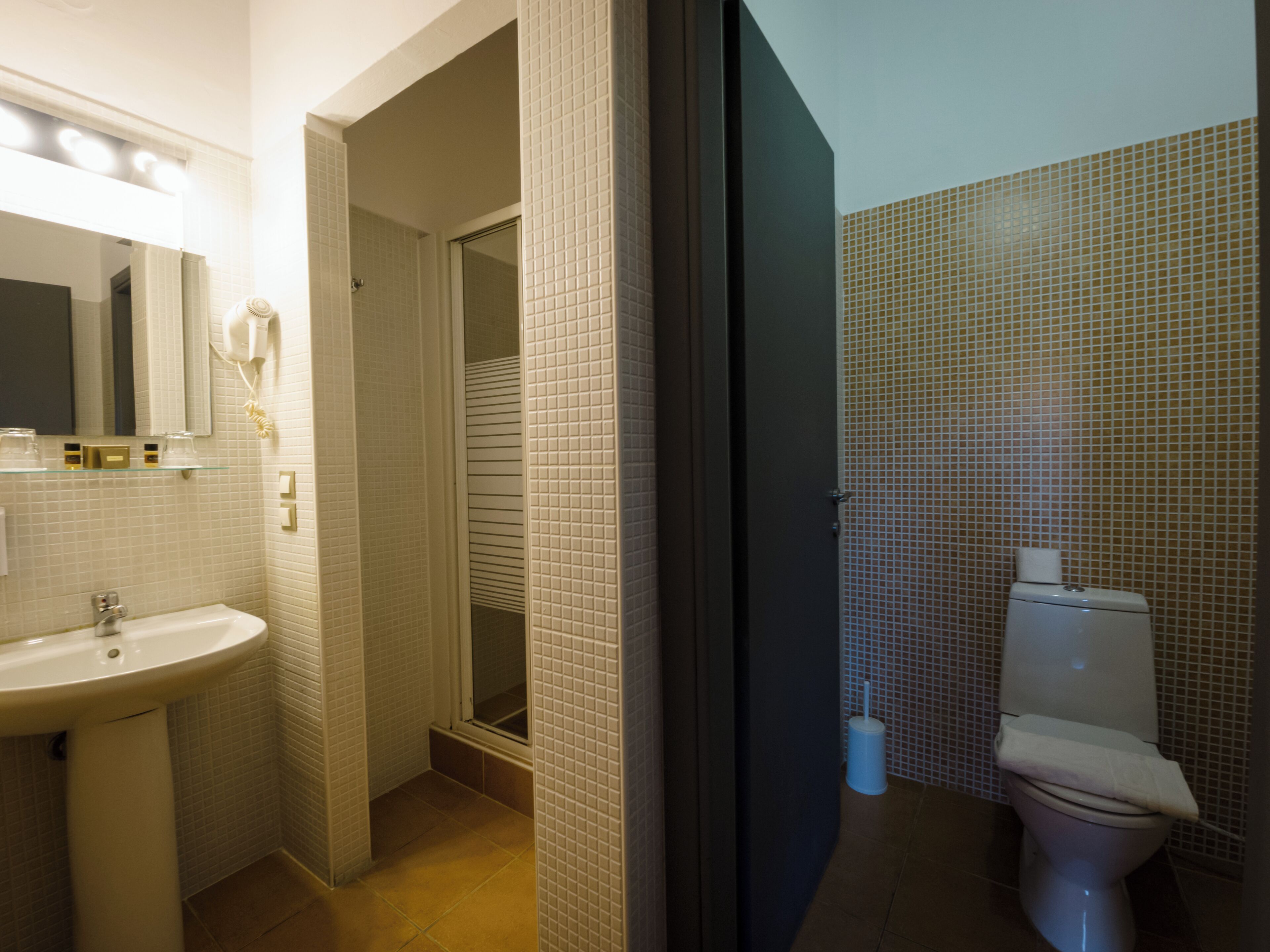 A bathroom with a sink, mirror, and toilet.