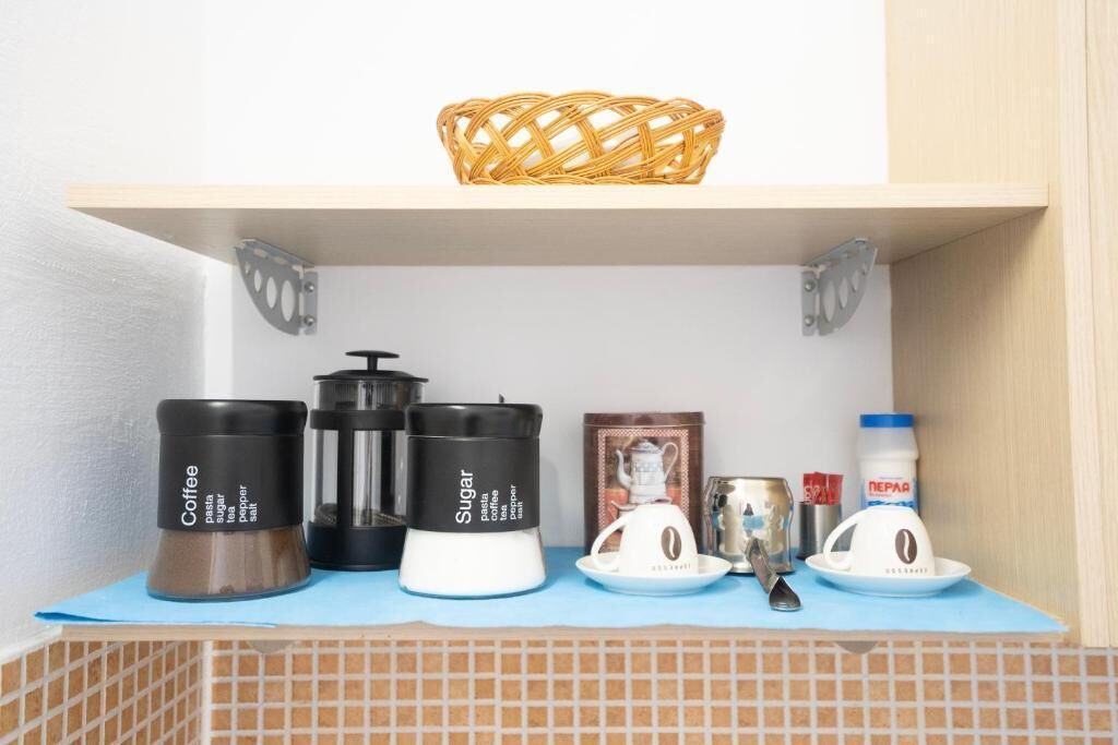 Une étagère de cuisine avec du café, du sucre et un récipient de pâtes.