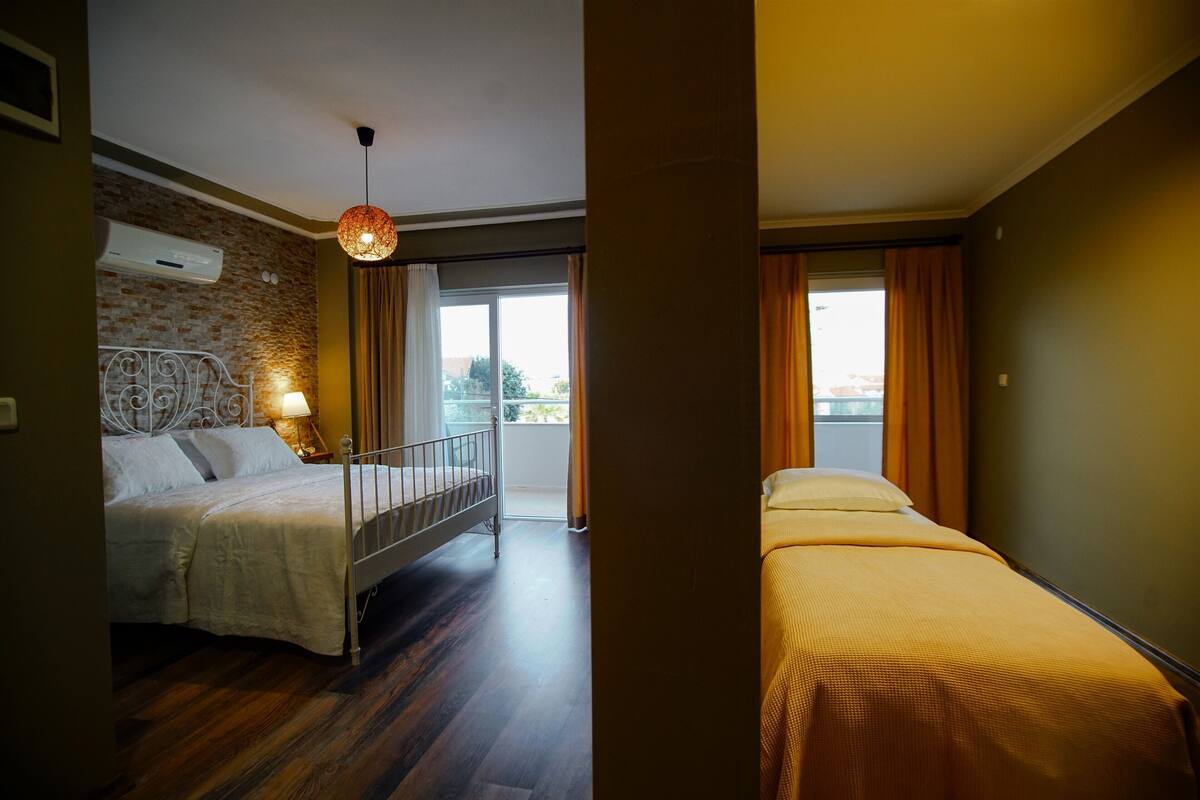 A hotel room with a bed, a balcony, and a view of the outside.