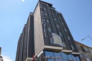 A tall hotel building with the name "Grand Hotel" prominently displayed on its facade. - Grand Park Hotel Corlu (Corlu)