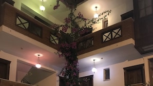 A multi-level outdoor patio with a wooden bench, a small table, and potted plants. - Hotel Mary's House (Selçuk)
