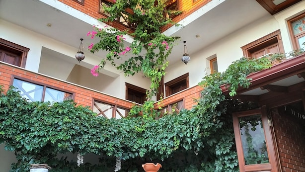 A courtyard with a central fountain, potted plants, and a seating area. - Hotel Mary's House (Selçuk)