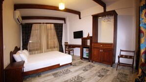 Un dormitorio con cama, escritorio, espejo y armario.