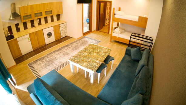 A compact living space with a kitchenette, a dining area, and a sofa. - Uzungol Kusva Apart (Çaykara)