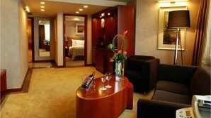 Un vestíbulo de hotel con un mostrador de recepción, un sofá, una lámpara y un cuadro en la pared.