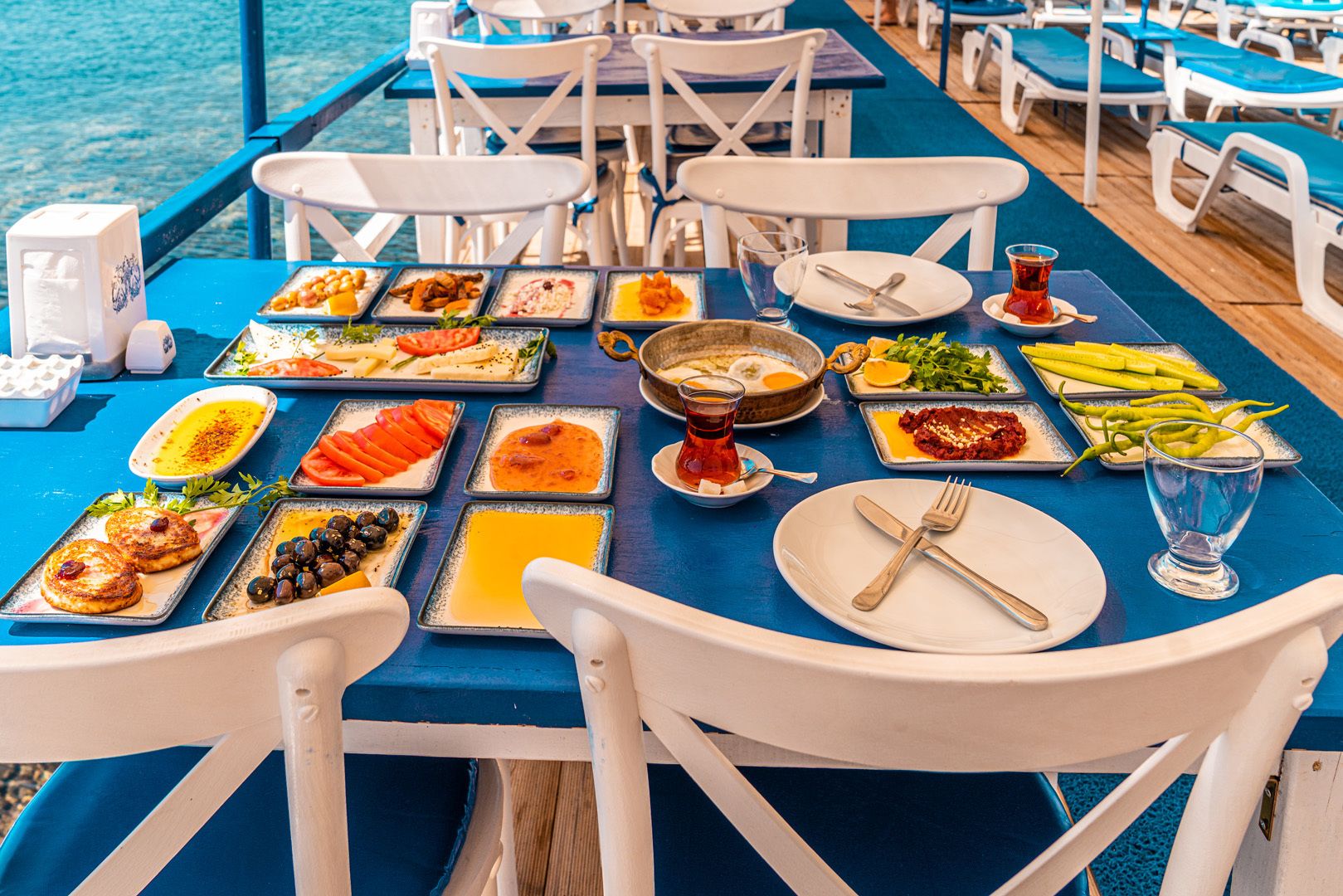 A dining table with various dishes and a glass of water, set on a blue tablecloth.