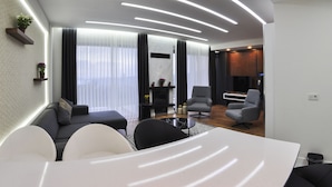 A modern living room with a sofa, chairs, a dining table, and a fireplace. - Nevras Resort (Sapanca)