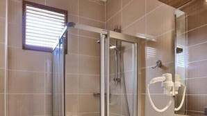 A modern bathroom with a glass-enclosed shower, a toilet, and a sink with a towel. - Antiphellos Pansiyon (Kas)