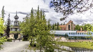 A traditional building with a distinctive onion dome, a covered greenhouse, and a gravel pathway.