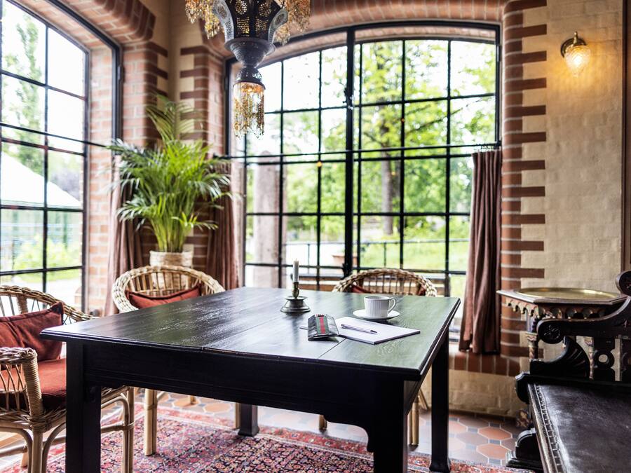 A dining area with a table, chairs, and a potted plant.