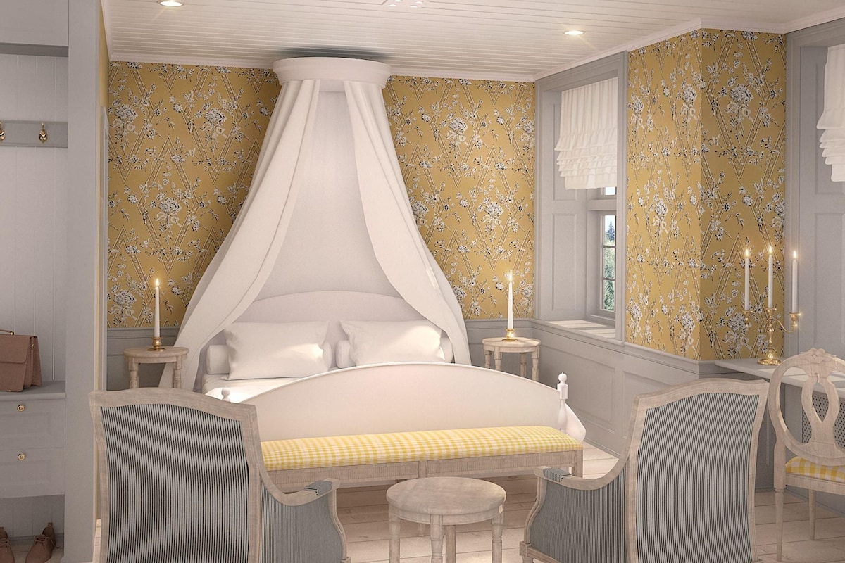 Une chambre à coucher avec un lit à baldaquin, des tables de chevet, une coiffeuse avec un miroir et une fenêtre avec des rideaux.