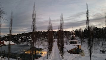 Un paisaje nevado con una estructura de invernadero de vidrio, una cabaña de madera e iglesia con cúpula.