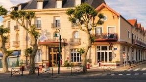 A historic building with a prominent entrance, multiple balconies, and a flag indicating a hotel. - Logis Hotel Le Majestic (Chatelaillon-Plage)